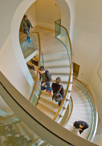 Students using staircase in С̳ campus building.